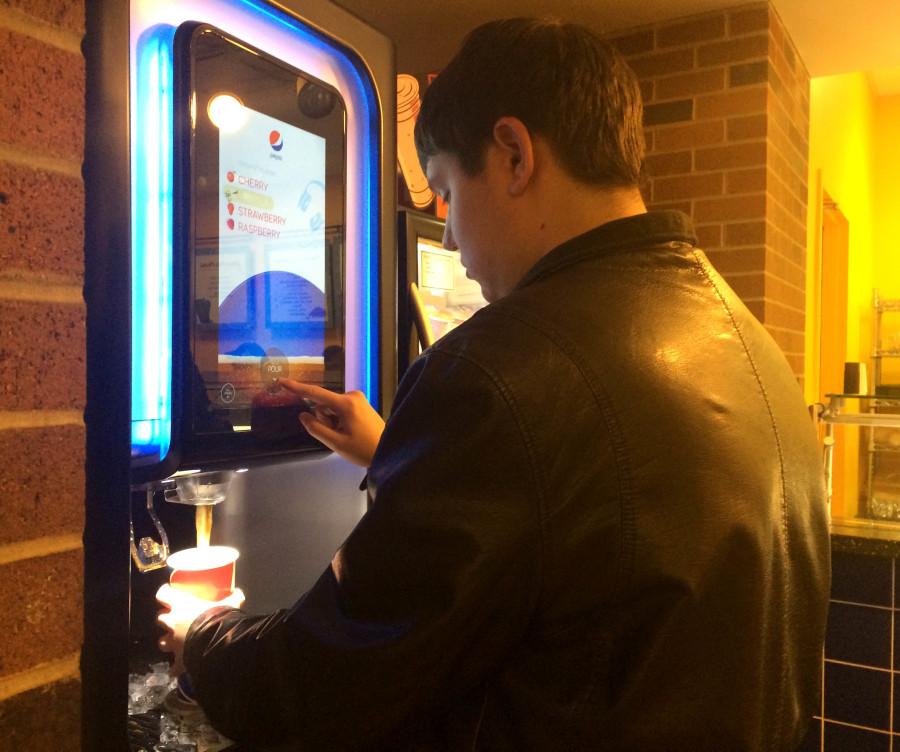 Student gets a beverage at the new pop machine in the Laker.