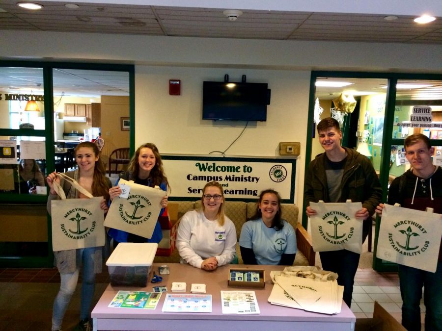 Sustainability Club members Emma Mader and Elly Buch, seated at center, help to hand out information and resources about recycling and composting in the Student Union. Freshmen Carly Holtzman, Julia Wrest, Nathan Brand and David Steets received free reusable tote bags for their involvement. 