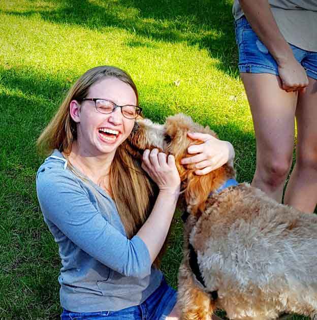 Junior Megan Pohl is greeted by a friendly dog. 