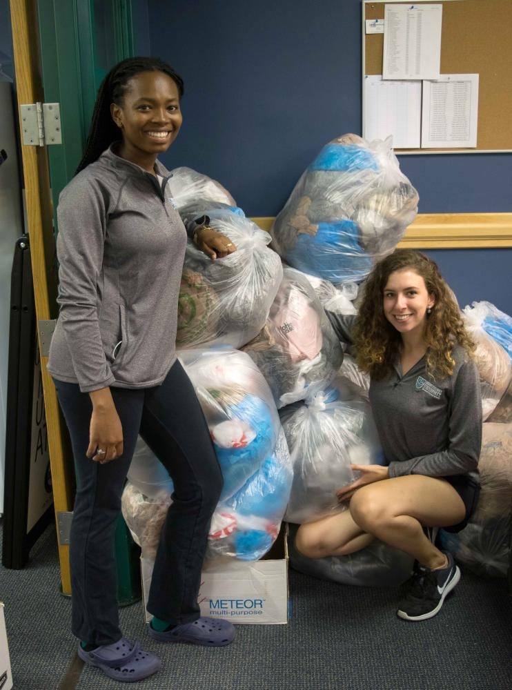 From left, Brittany Warren, Political Science major and MSG sophomore senator, and Rachel Lynch, junior Fashion Merchandising major, collect bags with the Mission and Sustainability Committee.
