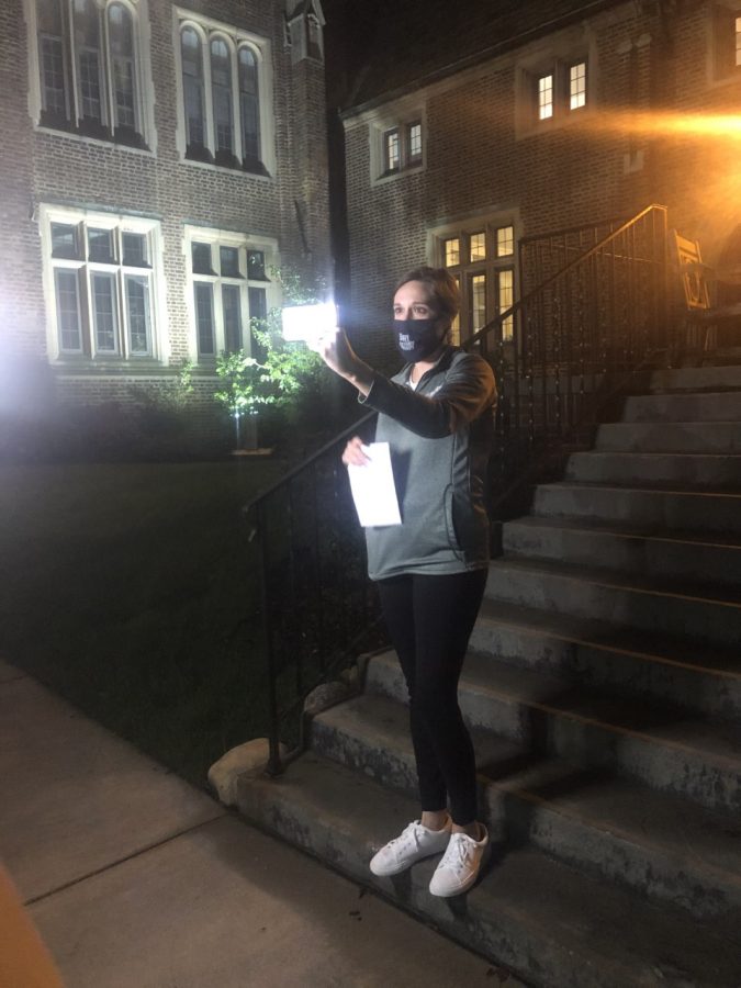 Lindsay Frank tells ghost stories on the steps of Egan Hall while livestreaming the event to alum via Zoom. 